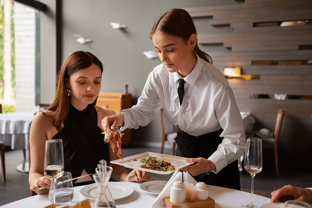 Restaurant server handing a diner a magnifying glass over a plate of food, illustrating the absurdity of asking researchers to inspect their own survey data for AI bots after collection